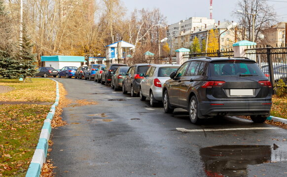 cars and crossovers in the city Parking lot near the fence. blurry focus