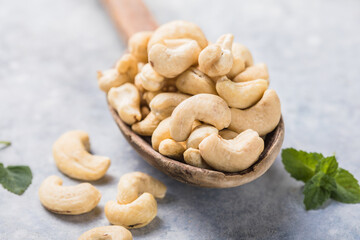 Cashew nuts in spoon top view. Healthy raw nuts of cashew fruit