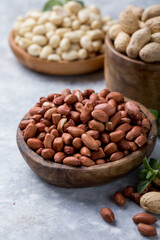 Raw dried fresh peanut nuts on a stone background