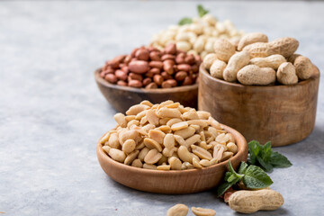 Roasted salted peanuts. Crispy nuts in bowl on stone table.