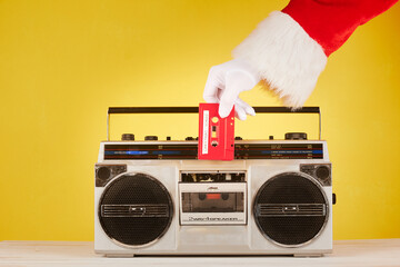 Santa Claus hand putting an audio tape on a radio cassette