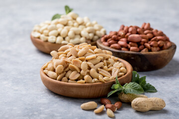 Roasted salted peanuts. Crispy nuts in bowl on stone table.