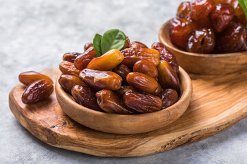 Dates or dattes palm fruit in wooden bowl is snack healthy.