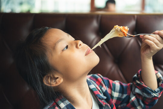 Children Girl Enjoy Eating Cheese From Pizza. Asian Kid People Enjoying To Eating Cheese Extend. Etiquette Food And Drink Concept 