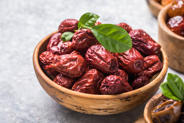Jujube fruits ( red date, Chinese date, Ziziphus jujuba ) in dish on rustic background