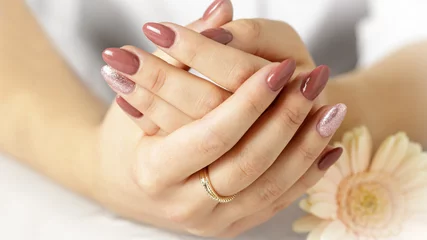 Badezimmer Foto Rückwand Elegant hands with fresh lilac pink manicure with daisy gerbera flower © BarTa