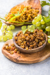 Golden raisins  in bowl on stone background, table top view. Dried fruit, healthy snack food