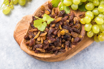 Golden raisins  in bowl on stone background, table top view. Dried fruit, healthy snack food