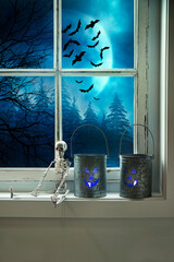 Metal tins with candles on window sill