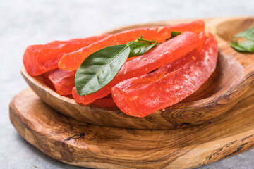 candied fruit, dried papaya with sugar in bowl on wooden table background.