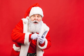Portrait of nice attractive handsome amazed Santa using phone gadget 5g fast speed blog blogger browsing multimedia isolated over red background.
