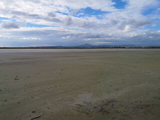 Larnaka Salt Lake during draught season. Flat landscape, muddy surface and cloudy sky.