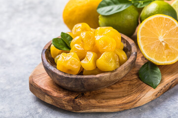 Сandied fruit, dried kumquat  with lemon flavor in bowl on stone table background.