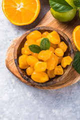 Сandied fruit, dried kumquat  with orange flavor in bowl on stone table background.