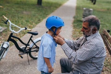 grandfather with his grandson preparing for a ride with bike