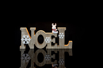 Décorations de Noël en bois avec reflet noir et espace pour texte.