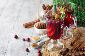 Mulled wine with christmas decorations. Christmas hot drink on wooden table with copy space.
