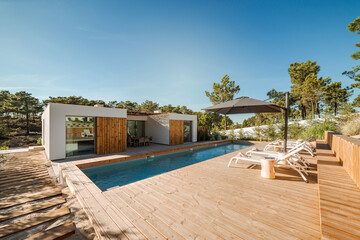 Modern house with garden swimming pool and wooden deck - obrazy, fototapety, plakaty