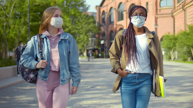 Diverse Students On University Campus Wearing Masks Keeping Social Distance