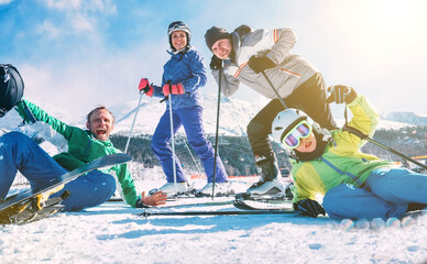 A family with little son dressed ski clothes sincerely smiling and laughing posing for photo on the...