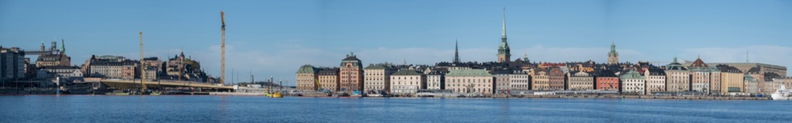 Skyline over the Stockholm old town Gamla Stan with boats, ferries, churches and old houses The Golden Bridge at the new sluice