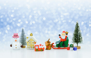 Santa Claus doll on sled with many Christmas decorations on snowing background, creative artwork Christmas and new year decorations concept