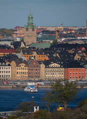 Obraz premium Commuter boat arriving to the quay of the old town Gamla Stan a sunny autumn day