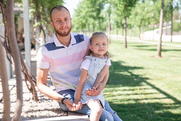 Fototapeta premium Little baby girl walking in a summer park with her father