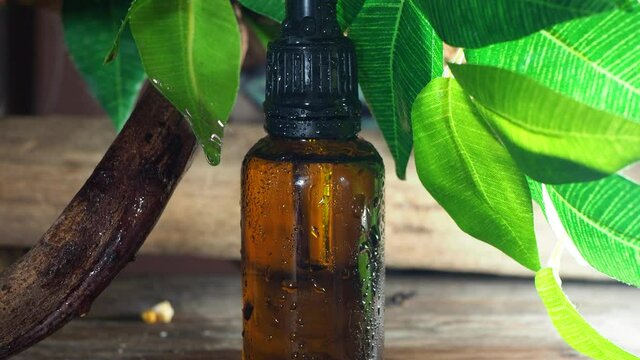Organic herbal essence. in glass bottle, alternative healthy medicine, essential oil with aroma herbs, scents and aromas in aromatherapy for wellness, spa and beauty, aqua drops fall from a leaf, 4K