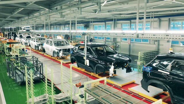Automobile, car factory conveyor. Factory premises with multiple unfinished automobiles