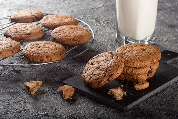 Oatmeal cookies with chocolate chips and milk. Cookies on a dark background with milk.