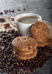 Oatmeal cookies with chocolate chips and coffee. Cookies on a dark background with coffee and coffee beans.