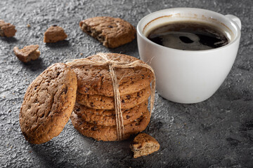 Oatmeal cookies with chocolate chips and coffee. A bunch of cookies with a mug of fresh coffee.