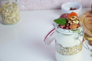Healthy breakfast overnight oats with fresh berries in a glass jar with dried fruits, apple and nuts, walnuts, almonds. with yogurt, cottage cheese, pudding. diet, keto diet