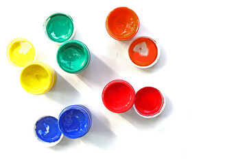 Opened cans of paint. View from above. colorful finger paints over white background