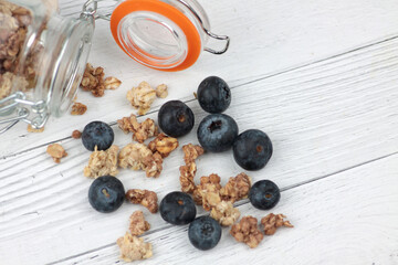blueberry and glass can of granola against gray background flat lay. Healthy eating concept