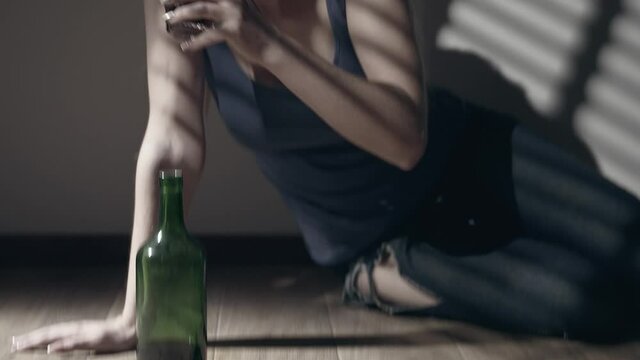 Miserable woman in depression, drinking alcohol