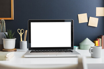 Fototapeta premium Trendy home office with laptop and stationery, green plants and books around, Homeschooling concept. Trendy, creative desk.