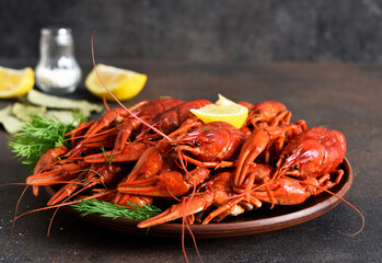 Red crayfish with dill, bay leaf and lemon in a plate.