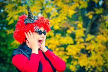 Surprised girl in halloween costume on the background of an autumn park. Scared girl in halloween accessories on the background of yellow leaves. copy space
