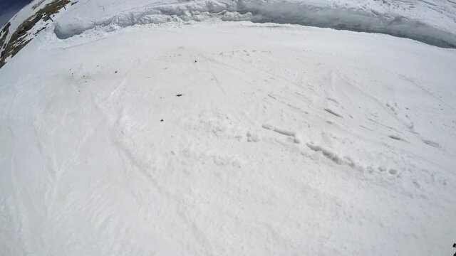 FPV snowboarder slides down prepared slope along track