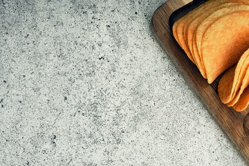 Potato chips on a wooden stand with sauces. Ready meal from the menu. Unhealthy food and beer snack.