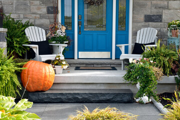 house with flowers and a giant pumpkin at Halloween.