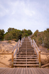 Escalera de madera rústica que da acceso a la playa de Las Redes, en el puerto de Santa María,...