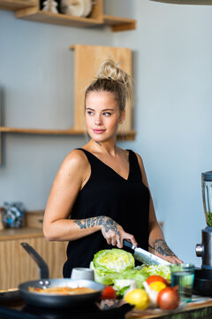 Bella mujer cocinando algo rico y nutritivo. Vida sana en la cocina. Mujer rubia cocinando.