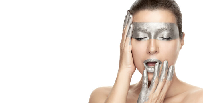 Silver skin makeup. Beautiful young woman with silver mask on eyes, lips and fingers