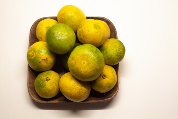 Tangerines on a wooden square plate, isolated