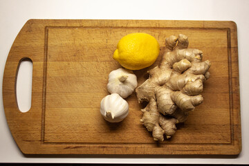 Ginger, garlic and lemon on a cutting Board isolated on a white background