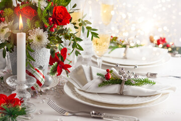 Festive table setting with winter flower arrangement on table decorated for holiday. Christmas or...