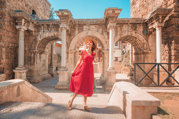 Obraz premium Happy female tourist traveler discover interesting places and popular attractions and walks in the old city of Antalya, Turkey. The famous Roman gate of Hadrian